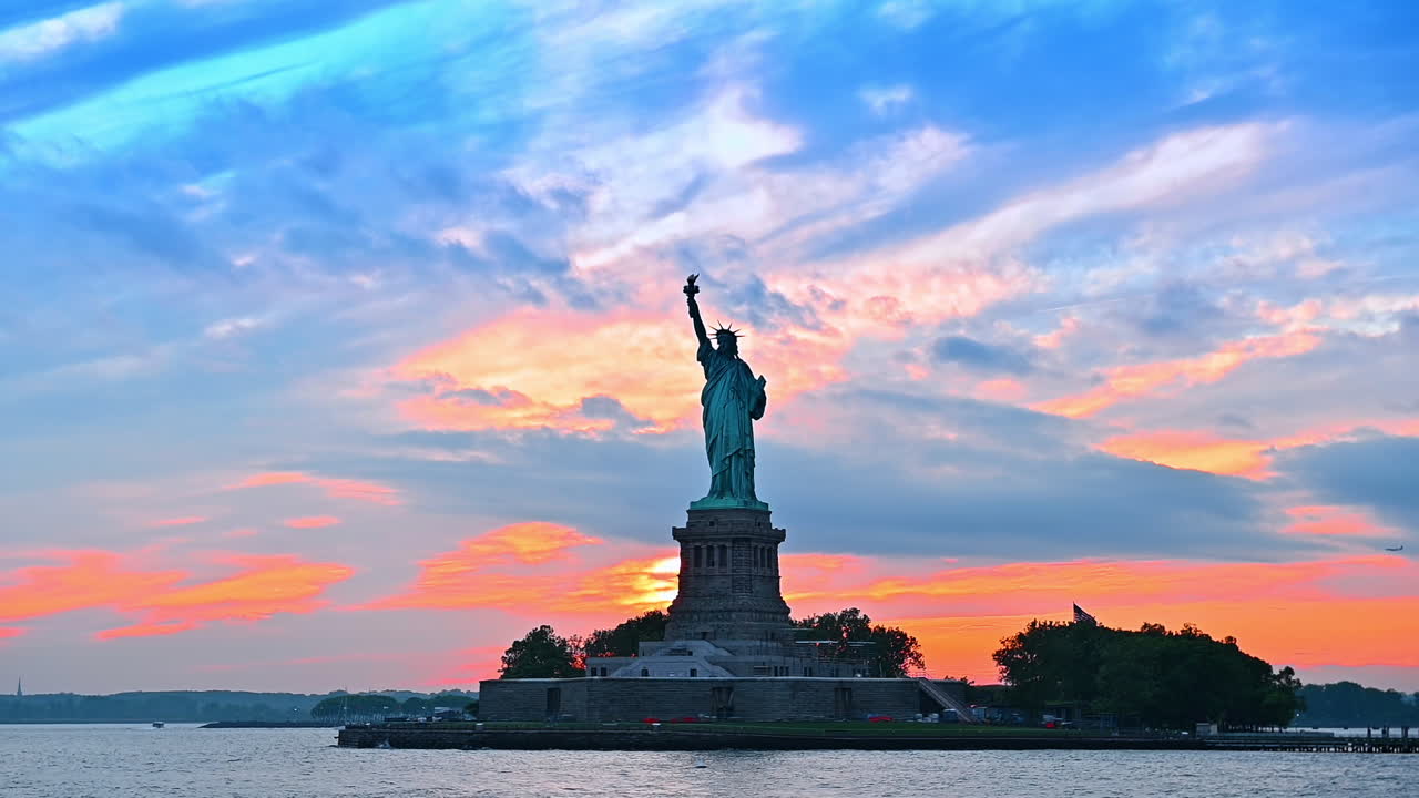 Blue and orange cloudy sky at sunset. Low angle view at the Statue of Liberty in New York, USA