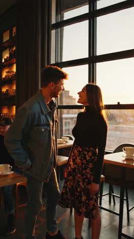 couple enjoying coffee at cafe at sunset