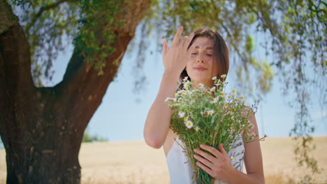 portrait woman embracing flowers in rural nature. beautiful smiling lady bouquet