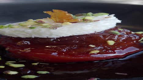 closeup of a delicious dessert with cherry, cream and pistachios