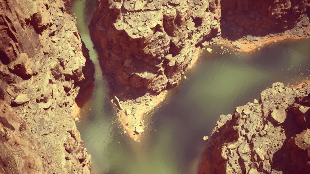 River winding through rugged canyons under bright sunlight in a remote area