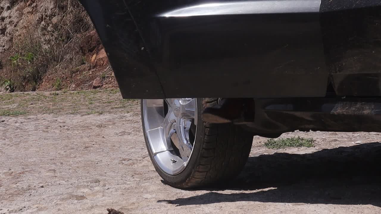 la puerta del camión negro se abre y una mujer vestida con botas de vaquero sale