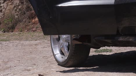 black truck door opens and a woman dressed in cowboy boots gets out