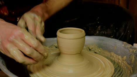 taza de conformación de alfarero profesional con herramienta especial en taller de cerámica