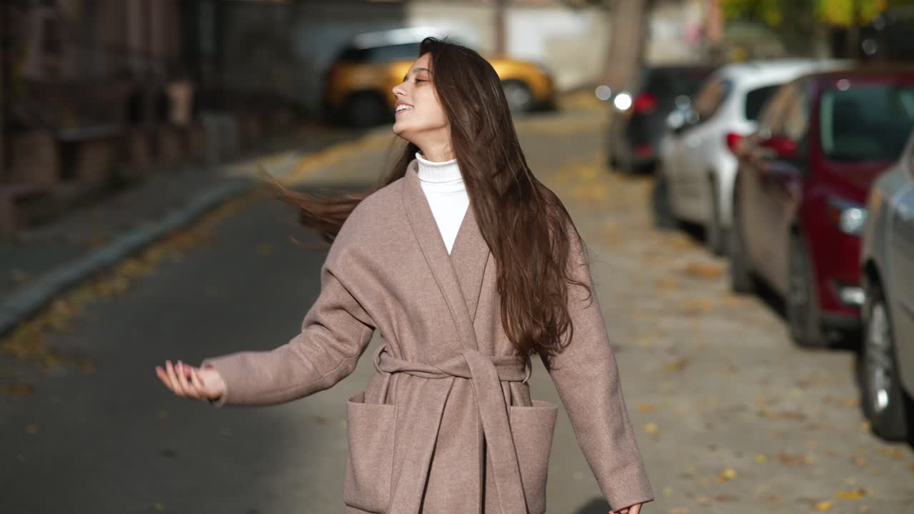 야외에서 베이지 코트를 입은 젊은 여성