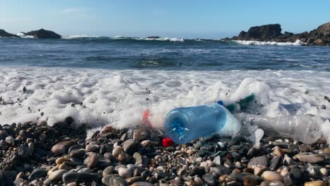 environmental pollution with plastic waste on beach near rocky coast