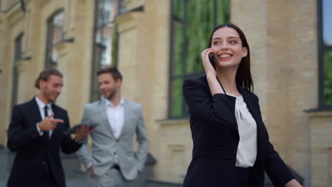 mujer sonriente usando el teléfono móvil al aire libre. gente de negocios corriendo a trabajar.