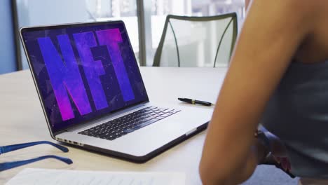 Video-of-african-american-woman-working-on-laptop-with-nft-on-screen