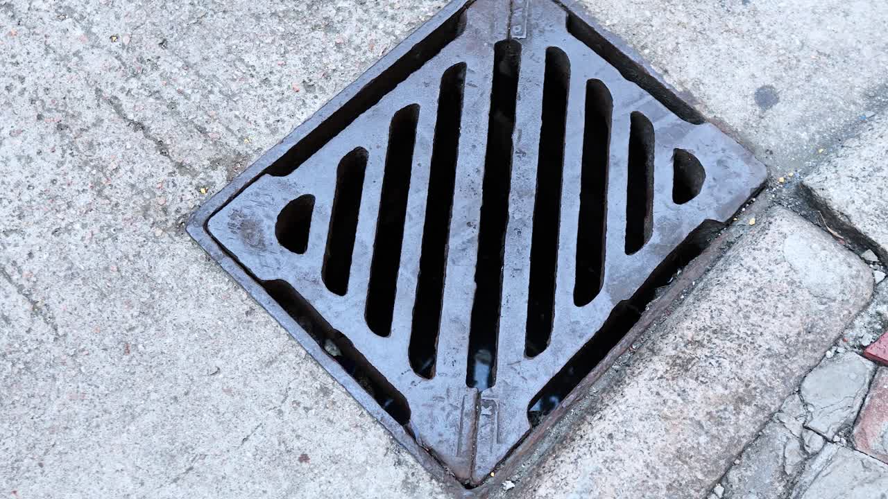 Person steps over a manhole cover