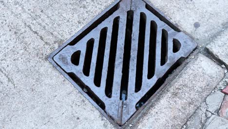 person steps over a manhole cover