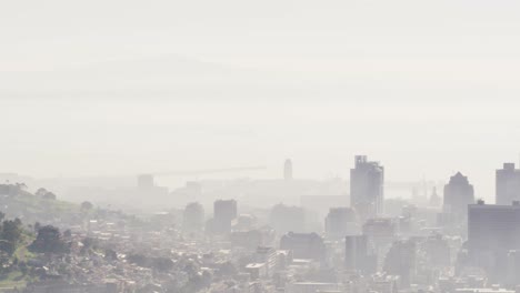 vista general del paisaje urbano con múltiples edificios modernos cubiertos de smog