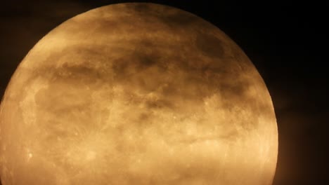 lapso de tiempo de una luna llena cubierta gradualmente por nubes oscuras en el cielo