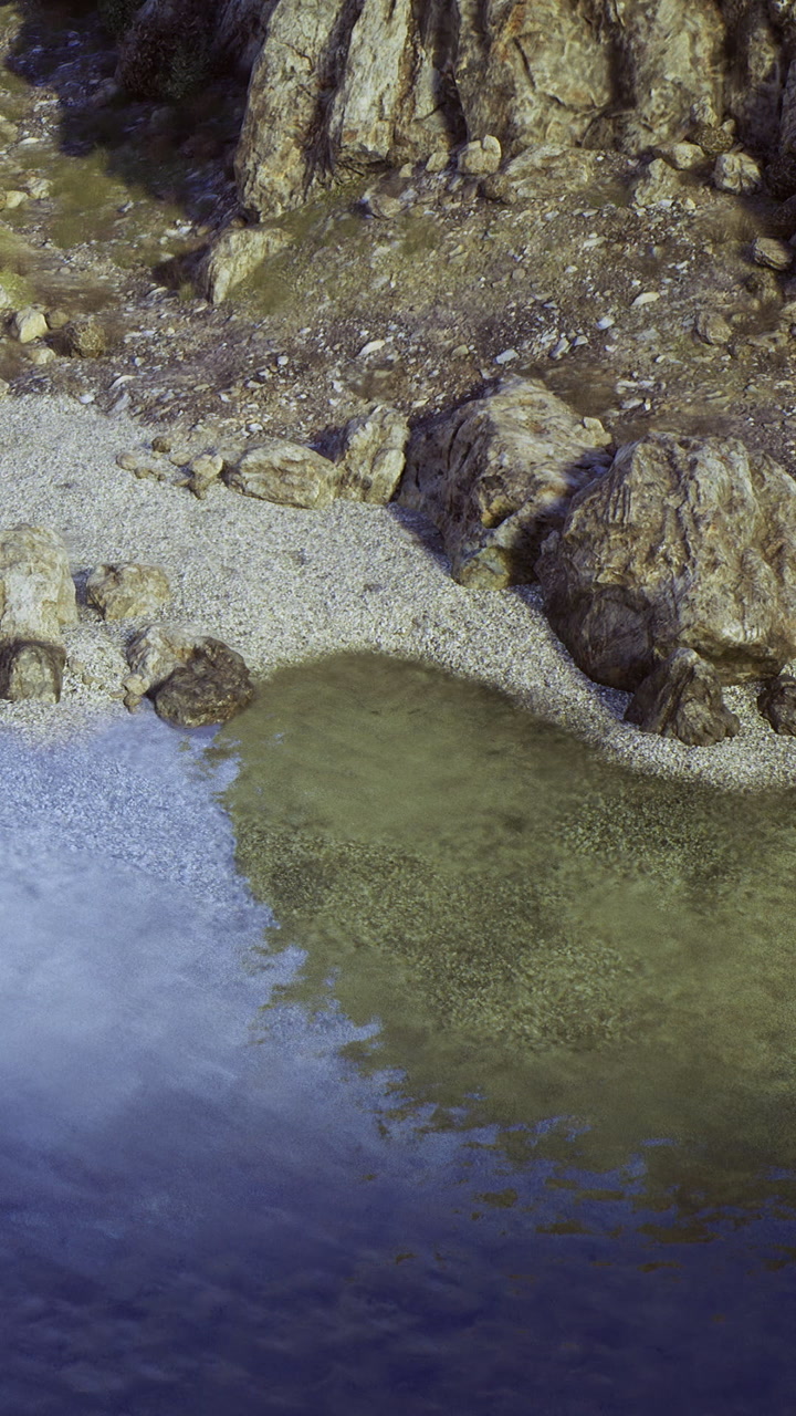 Clear water reflects rocks at a quiet beach during the day