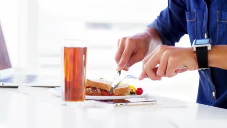hombre comiendo almuerzo con bebida en la oficina