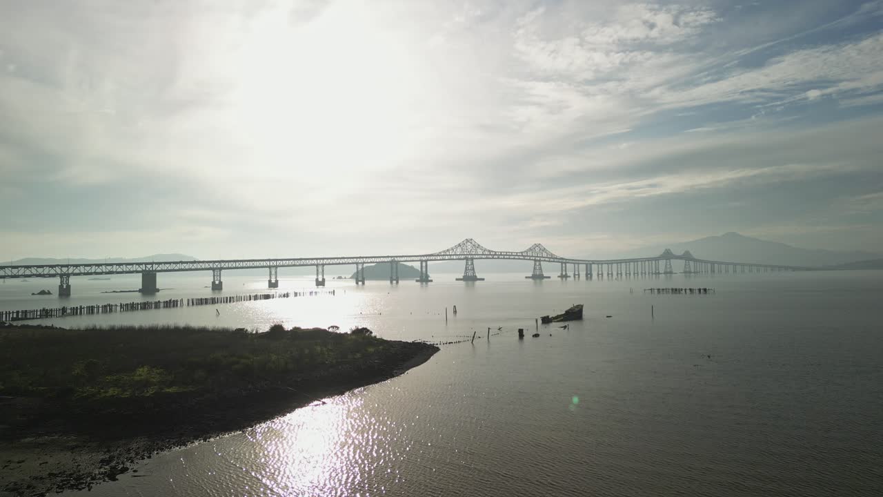 Backlit Richmond Bridge from Point Molate Beach Richmond California USA, aerial ascend