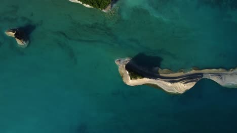 la isla de corfú es una formación de roca de arriba hacia abajo en aguas prístinas y claras del océano en la zona mediterránea de europa.