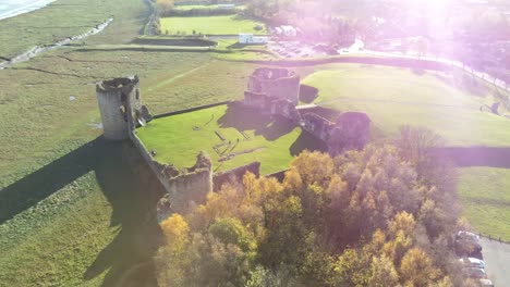 Historical-Flint-castle-medieval-military-ruins-landmark-aerial-view-orbit-left-over-trees