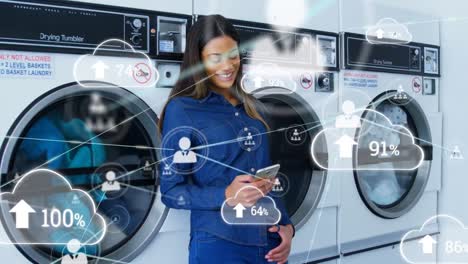 animation of connections, clouds with percent over biracial woman in launderette using smartphone