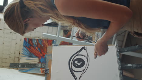 woman painting an abstract eye