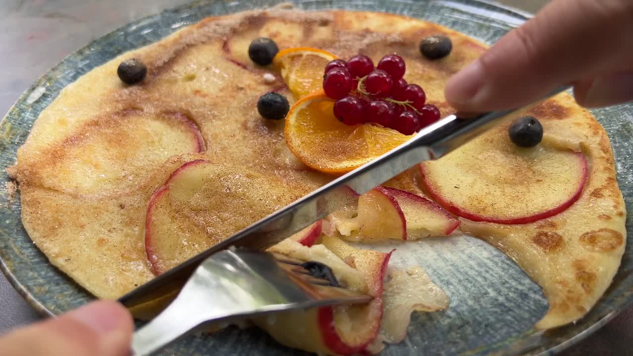 Eating fresh apple pancake close up