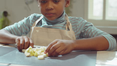 little boy cutting and eating pear on cooking masterclass