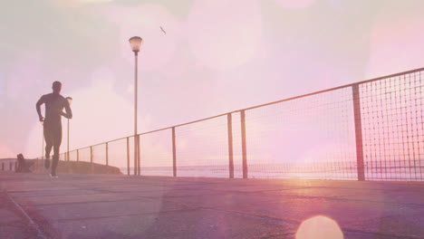 animation of spots over african american man running at beach