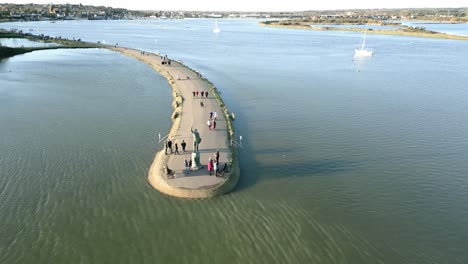 Maldon-Promenade-Walk-With-Several-Tourists-Visiting-Byrhtnoth-Statue,-Maldon,-Essex,-UK