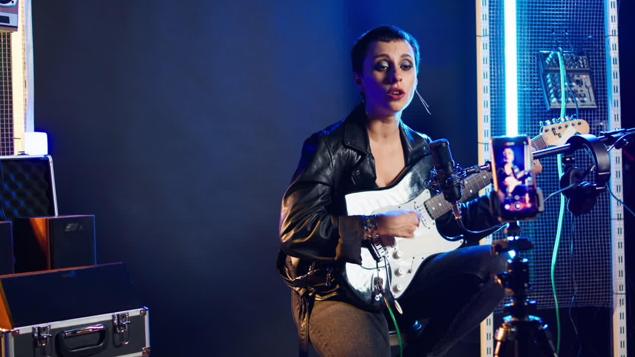 Woman Playing Electric Guitar and Recording Music