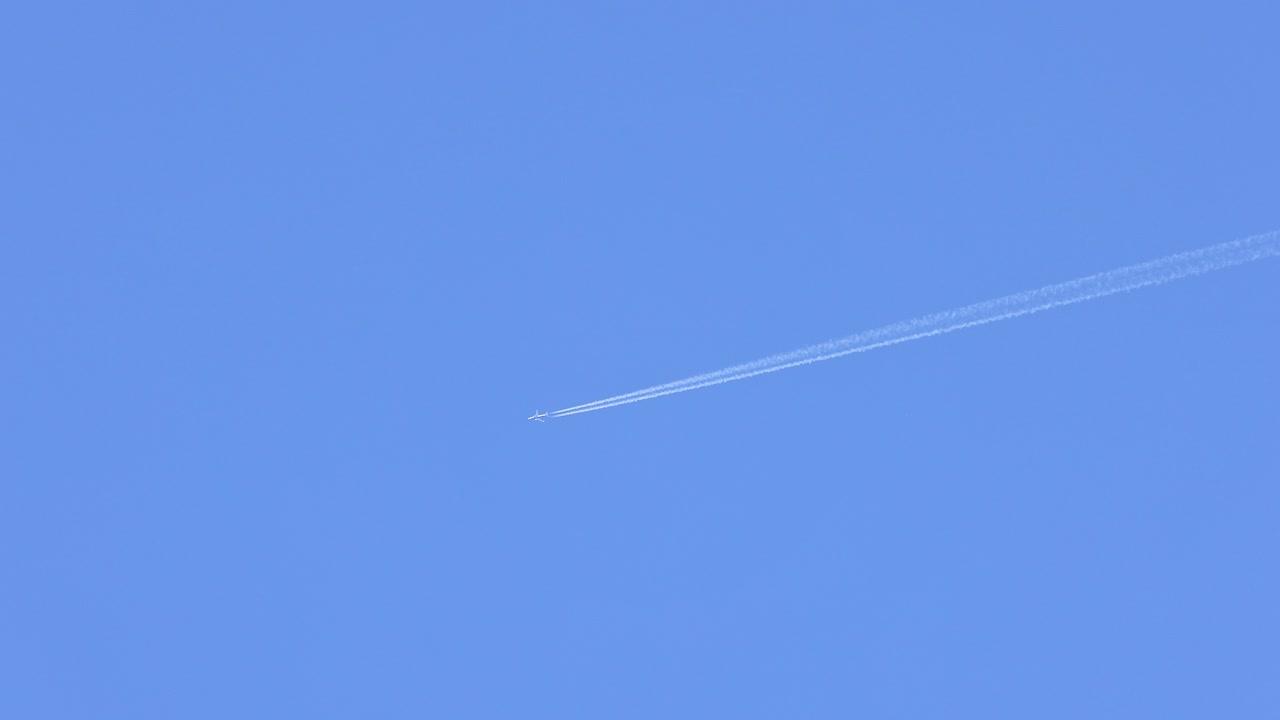 은 파란 하늘에서 콘트레일을 떠나는 비행기