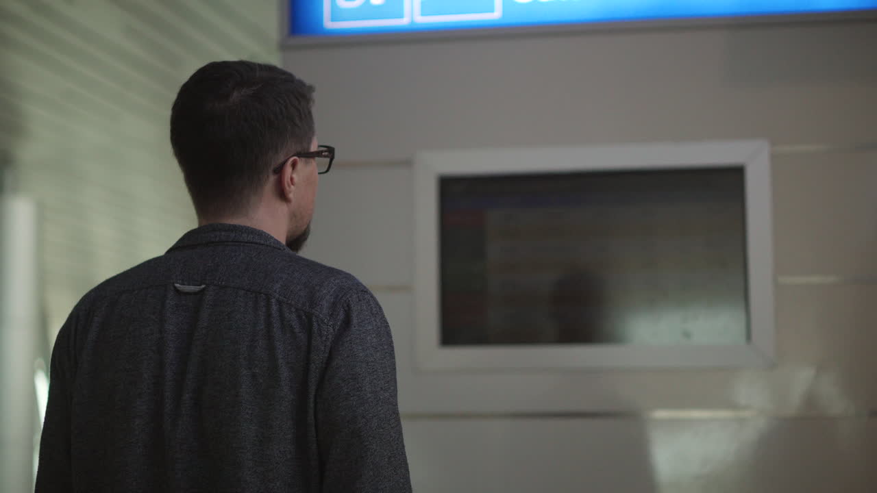 Man looking at airport information display