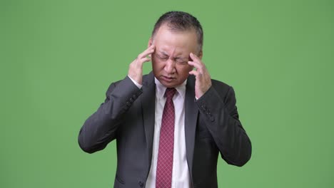 두통 을 고 있는 성숙 한 일본인 사업가