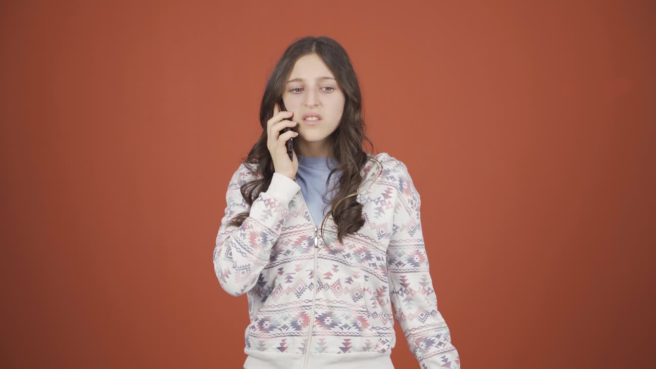 화난 젊은 여성이 전화로 이야기하고 있습니다.