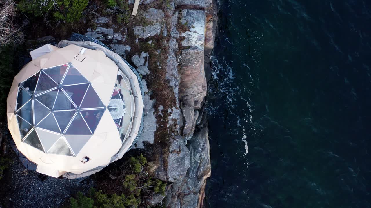 drone ascendiendo en la cúpula ártica - campamento ecológico en las costas rocosas de noruega
