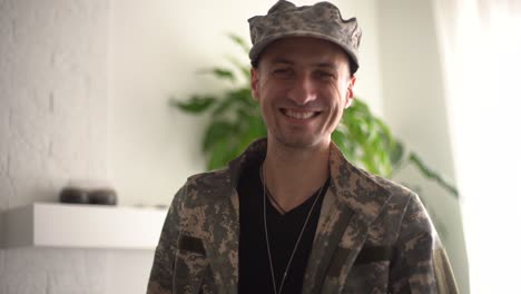 cinematic shot of young happy smiling male soldier in camouflage military uniform is making technology video call to her family or friends just turn back home after mission.