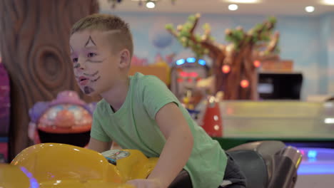 child is attracted with racing simulator in amusement park