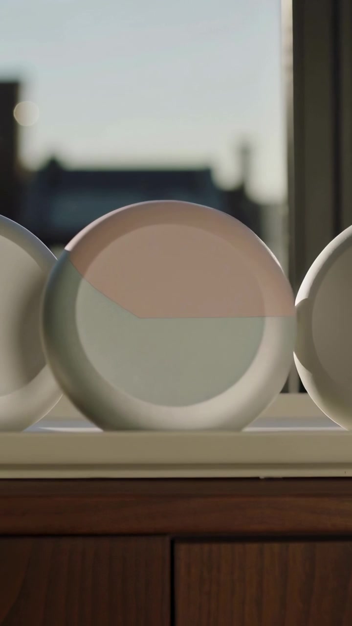 Vertical video: Rolling three round discs sliding on windowsill after push, showing pastel arc