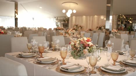 wedding reception setup with floral centerpiece and golden glasses location irrelevant