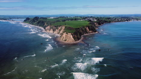 Olas-Oceánicas-Espumosas-Y-Promontorio-En-La-Playa-De-Maketu-En-La-Isla-Norte,-Nueva-Zelanda---Toma-Aérea-De-Drones