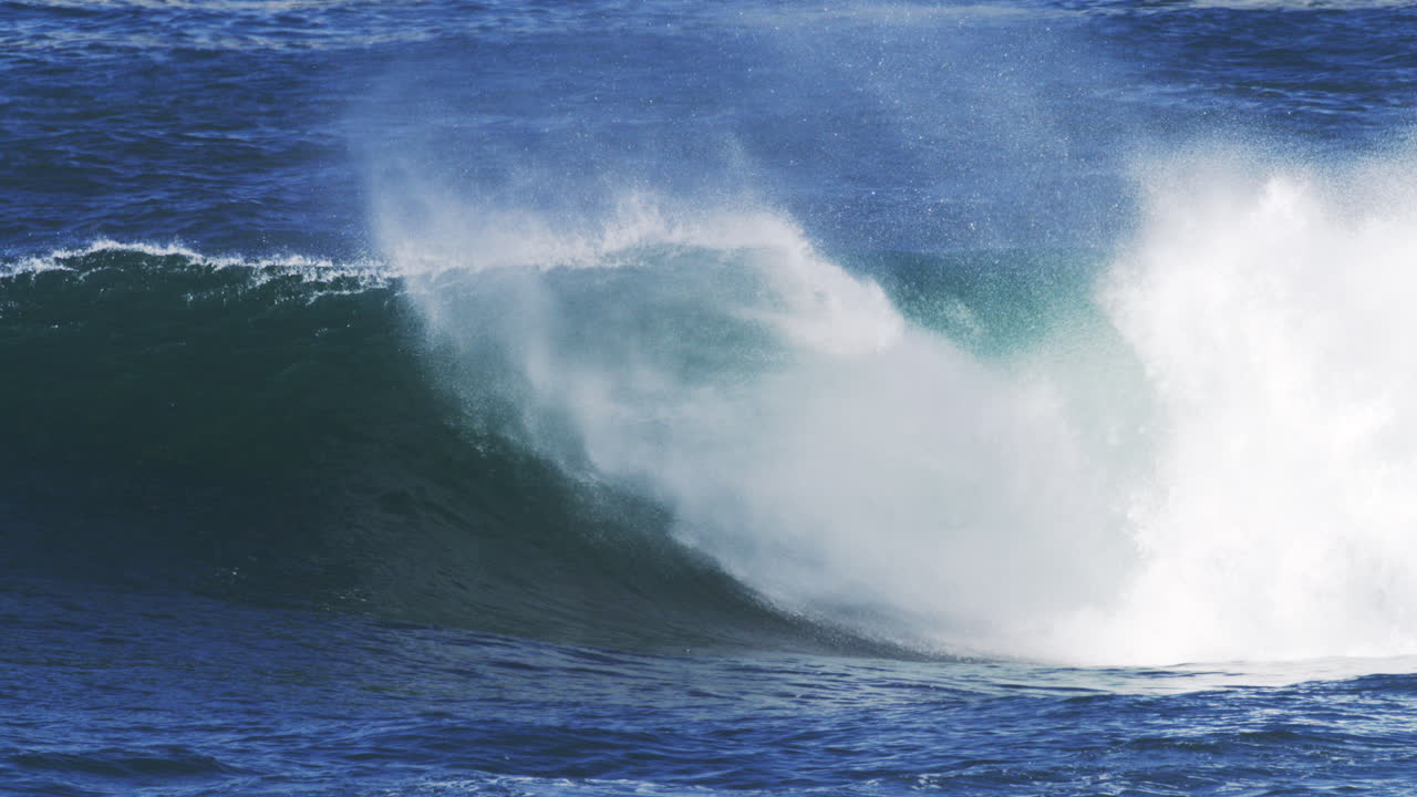 Crashing wave twists into foam, slow motion reveals layers of mist and spray