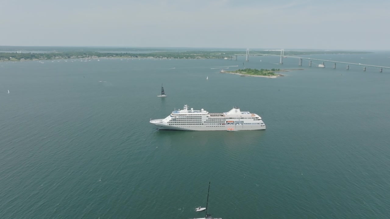 Droneoptagelser af en kæmpe båd, der overser Jamestown Bridge på Rhode Island i havet.