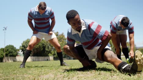 jugadores de rugby haciendo ejercicio de estiramiento en el campo 4k 4k