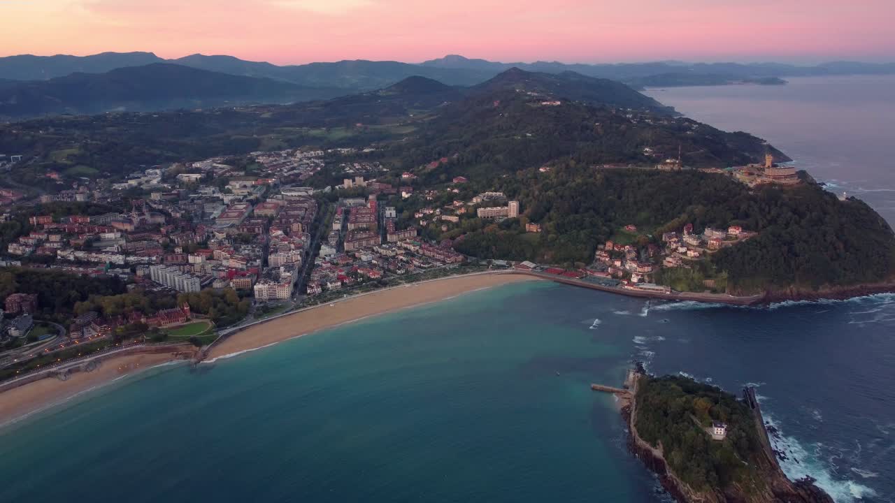 Veduta aerea della città di San Sebastián nella regione dei Paesi Baschi, nel nord della Spagna, faro al centro della baia e splendida vista del tramonto