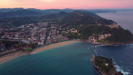 aerial view of san sebastián city in basque country region of north spain, lighthouse in the middle of the bay and stunning sunset view