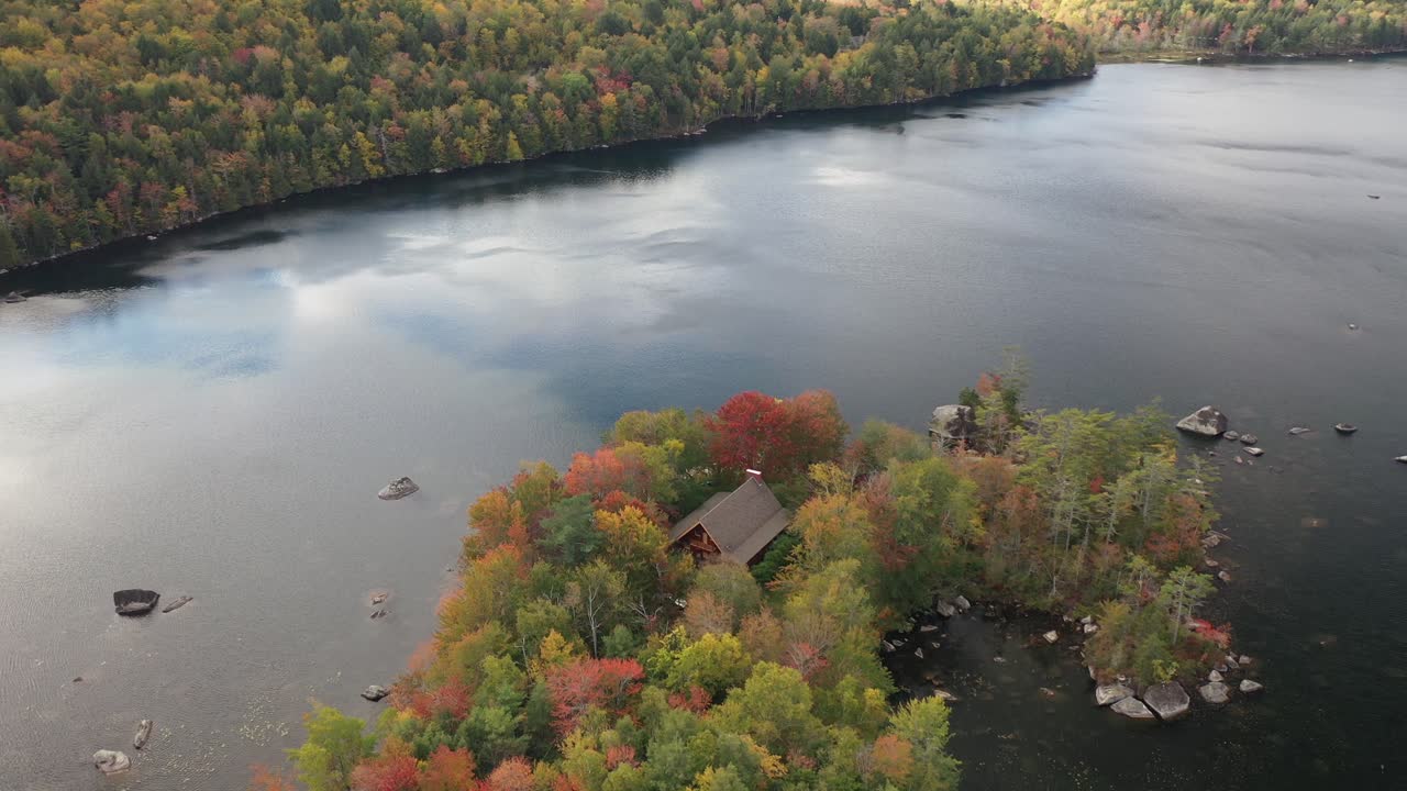vista aérea, casa frente al lago y colorido bosque llamativo en el campo americano