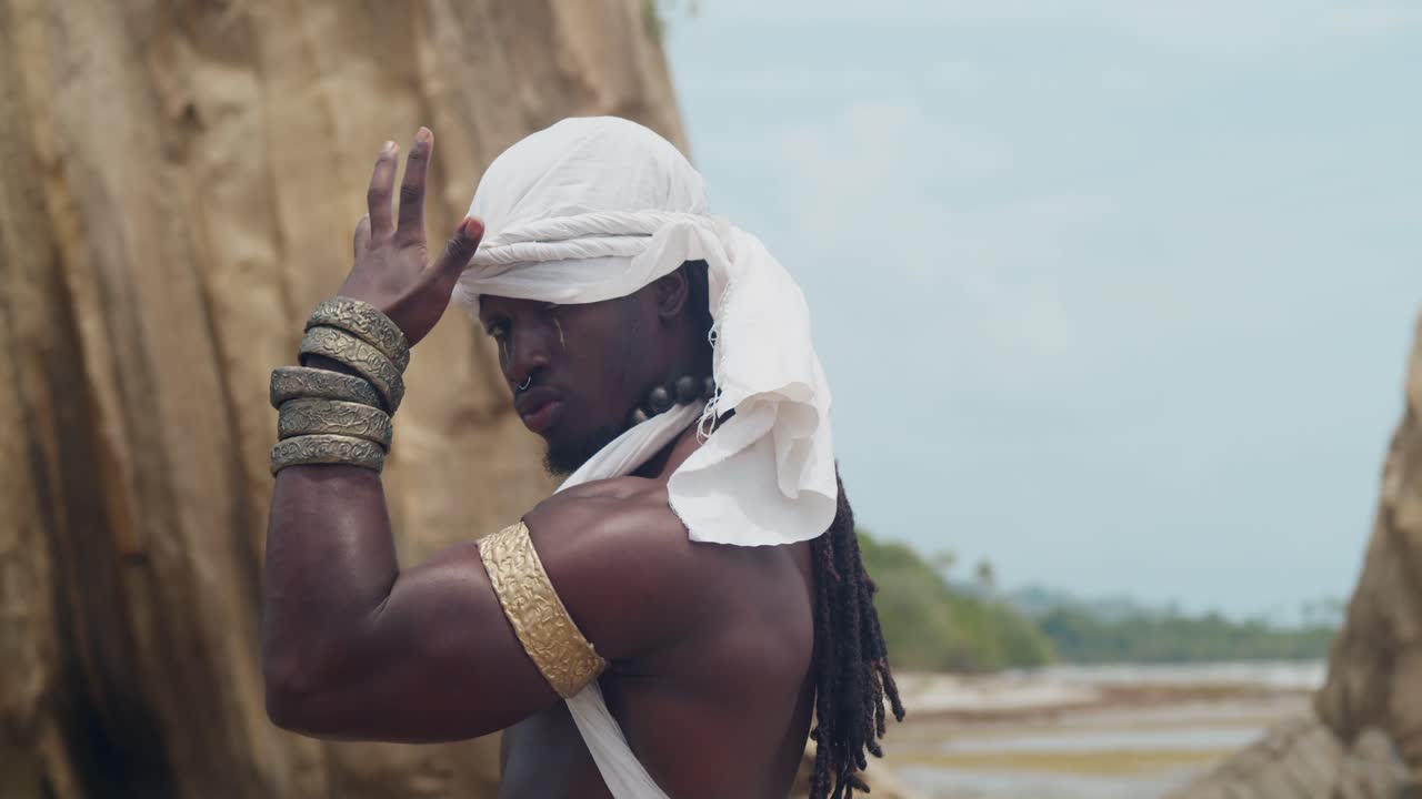 Displaying muscles and dark skin, a male cosplayer on the beach.