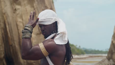 displaying muscles and dark skin, a male cosplayer on the beach.