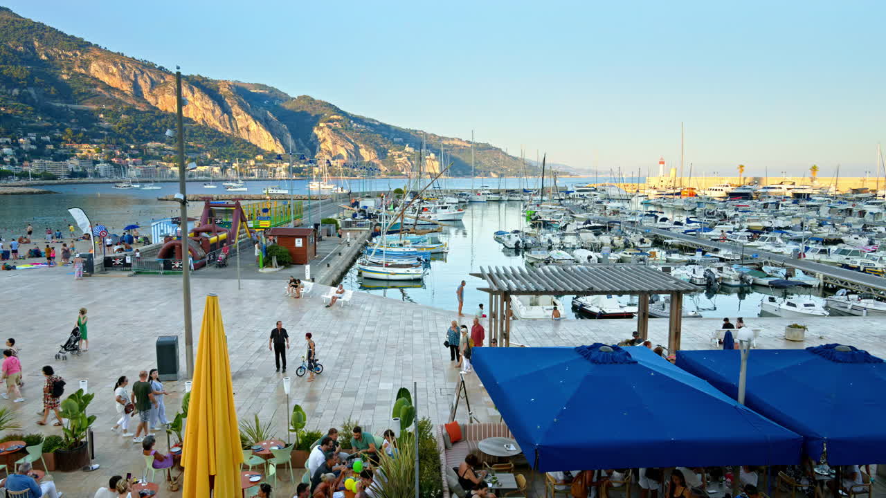 View of the Port de Menton in the French Riviera with people walking near it