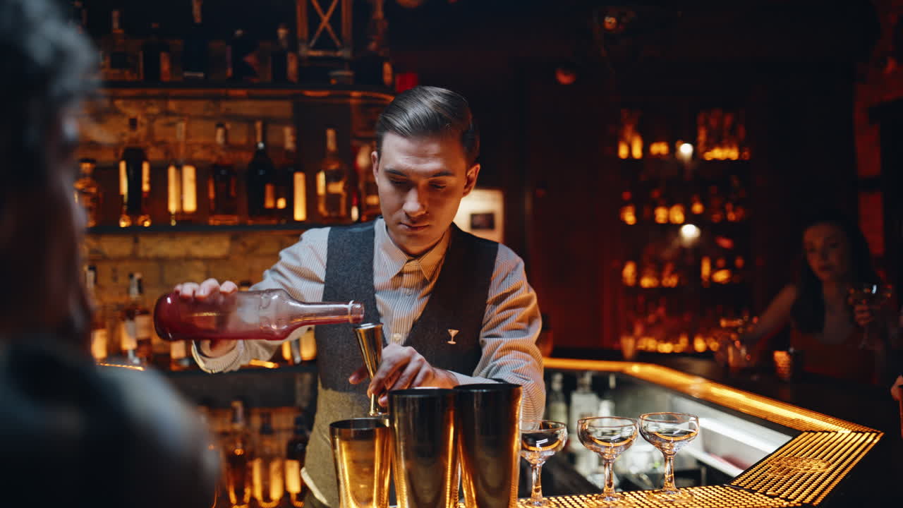 Barman experto sirviendo alcohol en una copa especial para preparar un cóctel en un bar nocturno