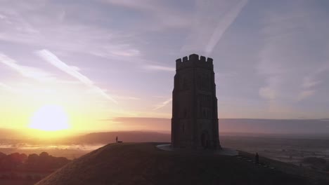 zooming out aerial shot of the sunrise over glastonbury tor, somerset