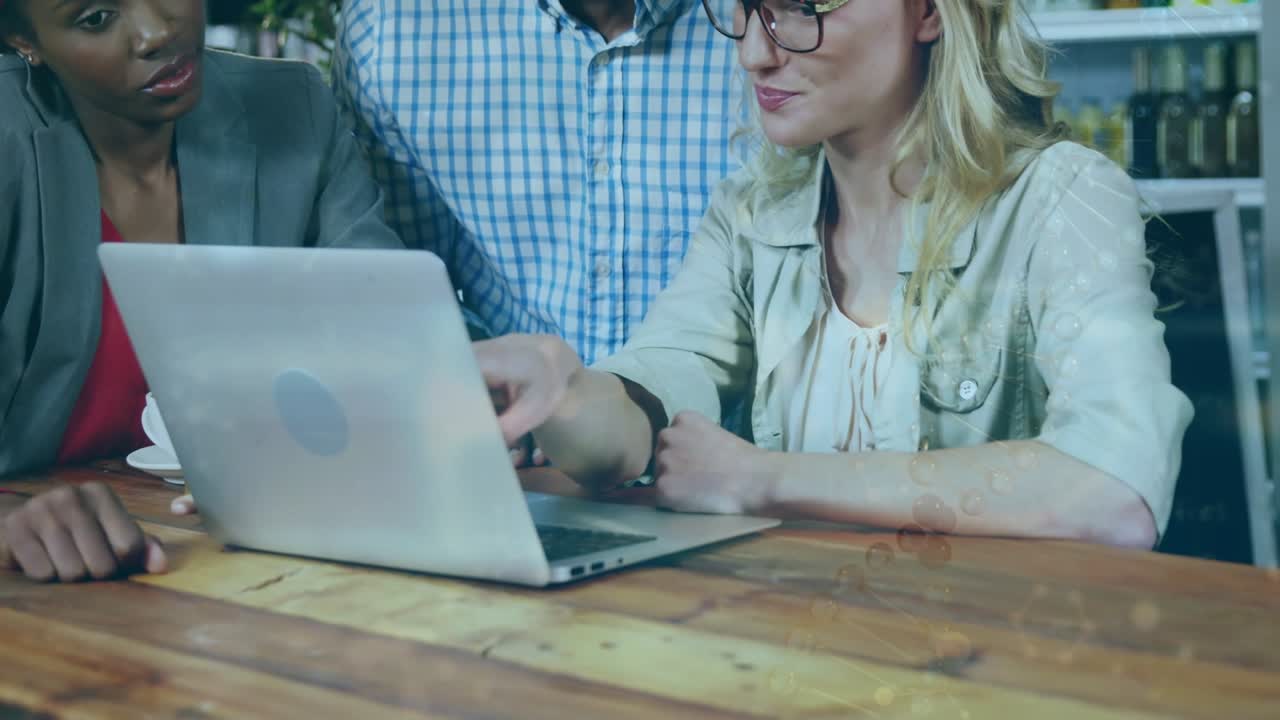 Animation of scientific data over diverse female and male coworkers using laptop